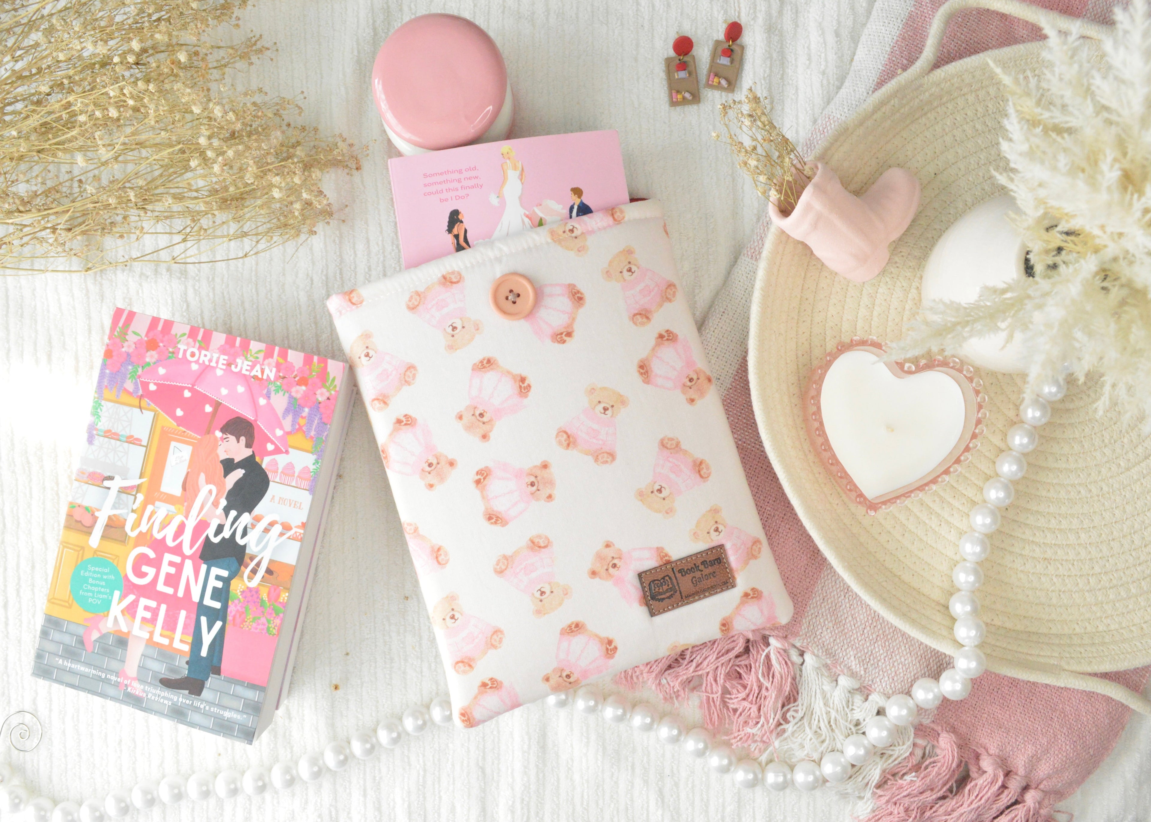Product display with a book, patterned fabric, and decorative items on a light surface.